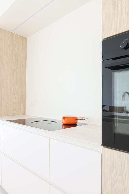 Detail van kookplaat met geïntegreerde afzuiging in moderne maatkeuken.