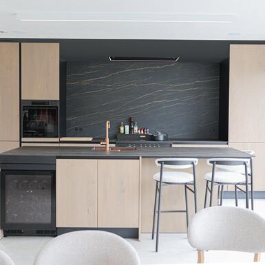 Maatkeuken Izegem met kookeiland, eiken fineer en keramisch werkblad Noir Desir.